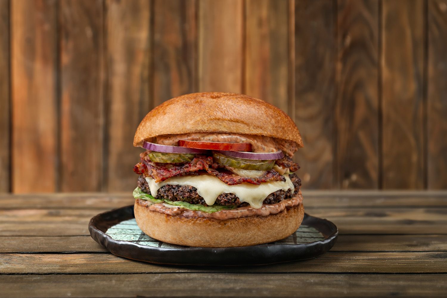 Plate with tasty black burger table